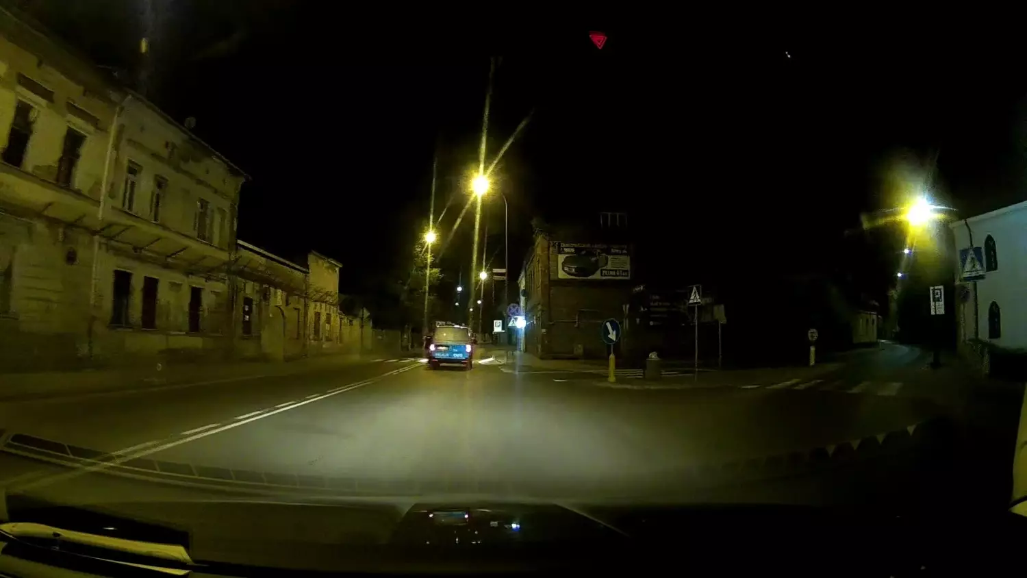 Policjant KMP poprawia znak drogowy